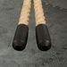 Pair of battle rope handles with black grips on a textured gray gym surface